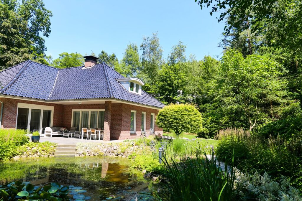 Vijver met waterplanten voor een woning met schilddak in Wageningen