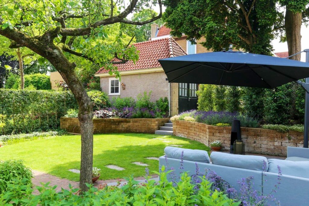 Loungeset onder een parasol in een tuin met keerwanden in Arnhem