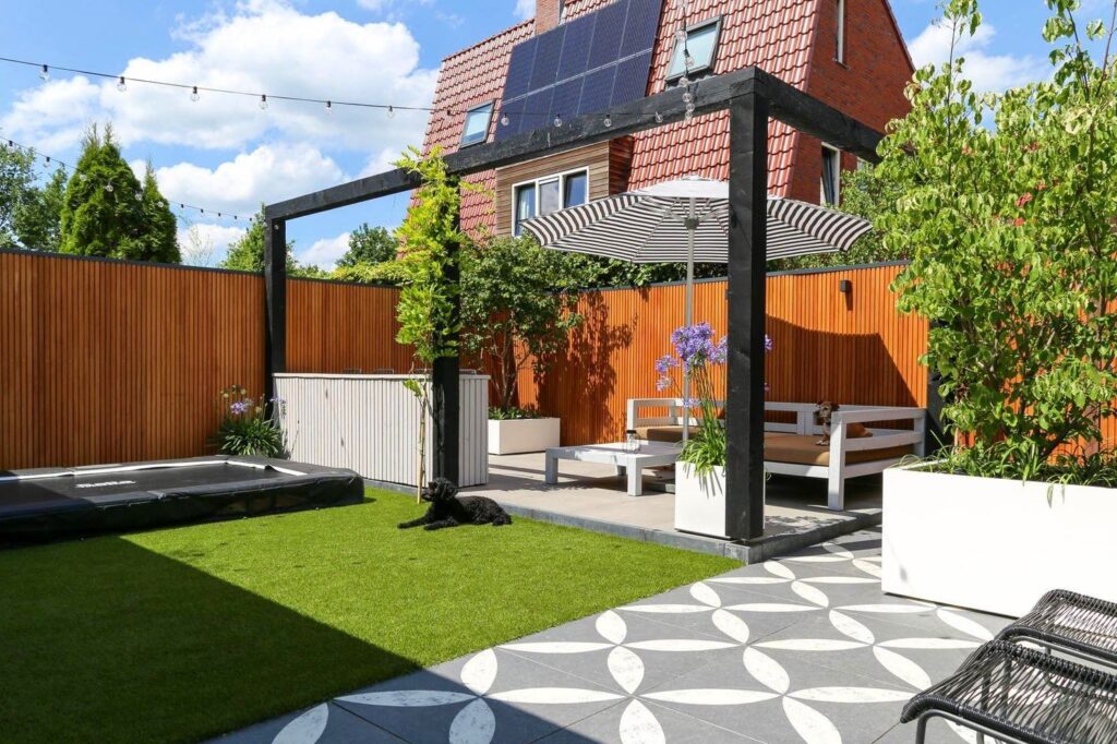 Patiotuin in Arnhem met kunstgras, sierbestrating en zwarte pergola
