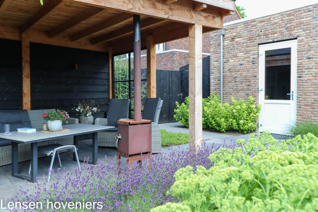 Eethoek onder de overkapping met lavendel en vrouwenmantel