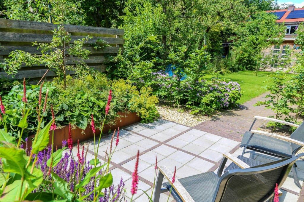 Terras met tuinstoelen en vaste planten in een stadstuin in Wageningen