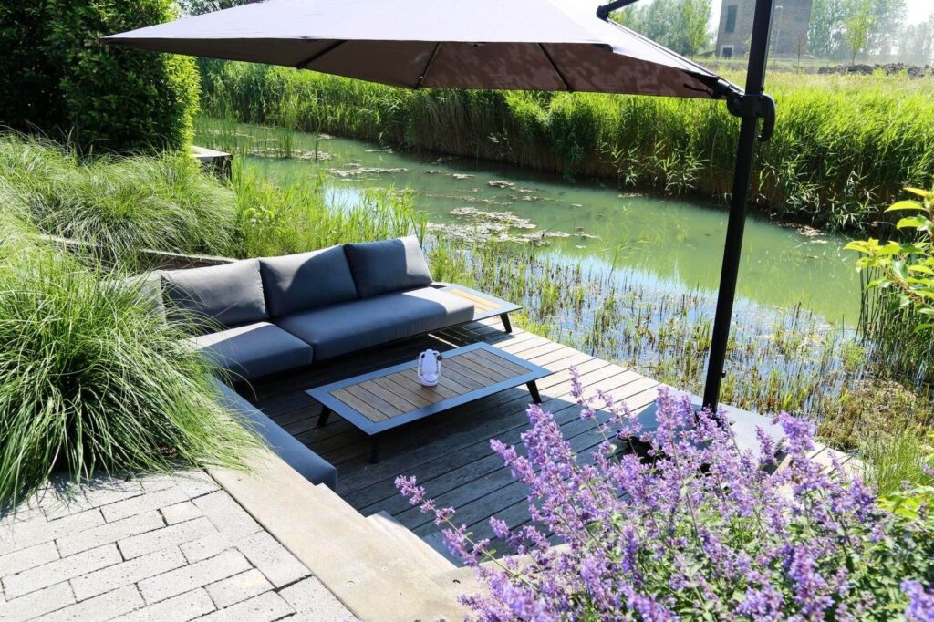 Loungebank aan het water met kattenkruid en siergras in Arnhem