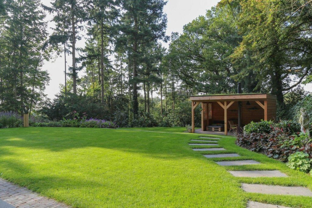 Stapstenen door het gazon naar het tuinhuis