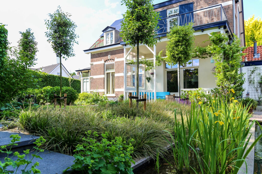 Zwemvijver met siergrassen achter een vrijstaande woning in Oosterbeek