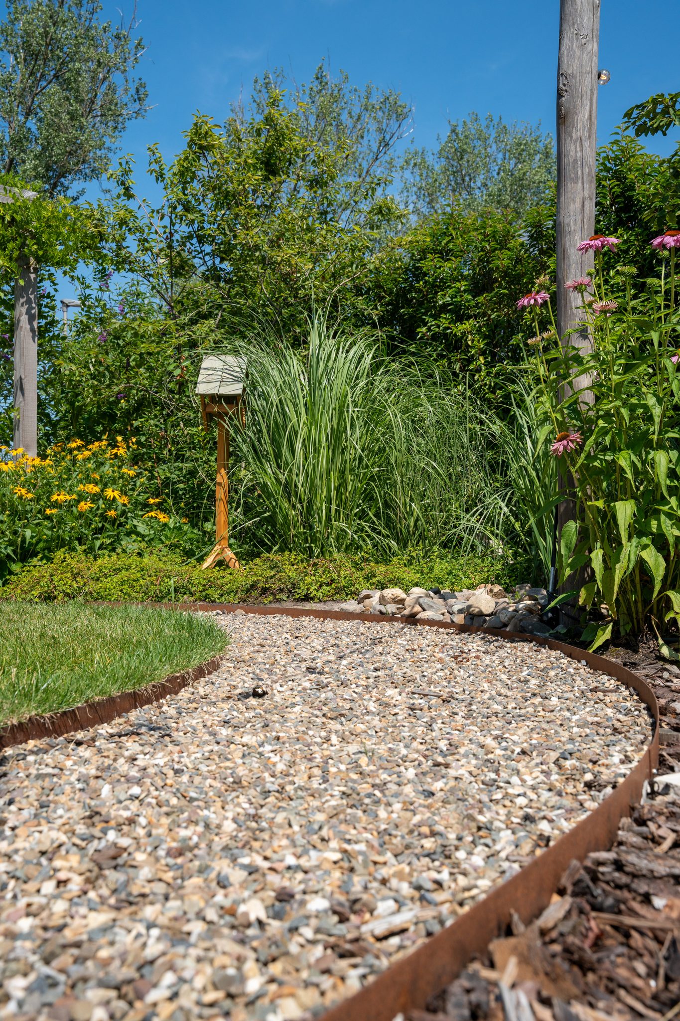 Grindpad met cortenstalen rand langs een border
